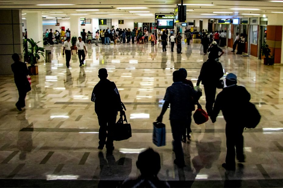 Travelers walking through a busy airport terminal